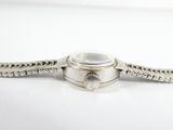 a close up of a silver watch with a chain around it