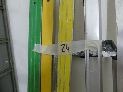 several skis are lined up against a wall in a storage room