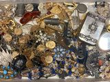 une boîte blanche remplie de nombreux bijoux et d'une paire de ciseaux