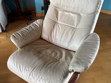 a white recliner chair in a living room with a blue wall