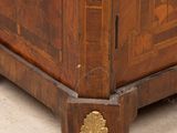 a wooden cabinet that has a gold decoration on it