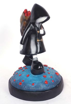 figurine of a woman in a black coat with a red rose in her hand