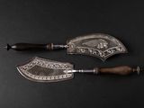 pair of silver plated knives with wooden handles on a black surface