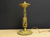 une lampe de table ancienne en laiton, avec un abat-jour blanc, posée sur une table en bois