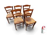 quatre chaises en bois sont alignées sur une surface blanche
