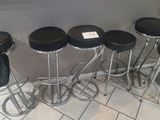 several stools are lined up against a wall in a restaurant