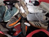 many pairs of shoes in a bag on the floor