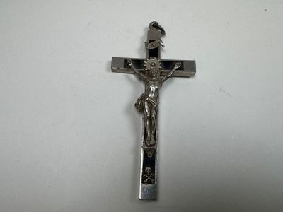 silver crucifix on a white table with a white background
