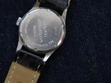 a close up of a wrist watch on a blue cloth