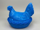 un poulet en plastique bleu posé dans un panier sur une table