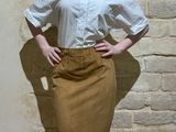 a woman that is standing in front of a brick wall