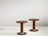 une paire de tables d'appoint rondes avec des pieds en bois et des pieds en métal