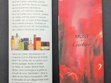 booklet of perfumes and perfume bottles on a table with a black background
