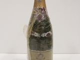 an old bottle of champagne wrapped in plastic on a white surface