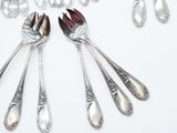 a lot of silver spoons and forks on the table