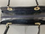 an image of a black purse hanging on a white wall