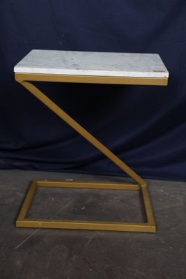 a white and gold side table with a marble top