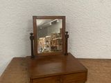 a small mirror sitting on top of a wooden table