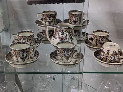de nombreuses tasses et soucoupes exposées dans une vitrine