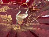 two birds that are standing in the grass on a red plate