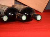several bottles of wine are lined up on a red table