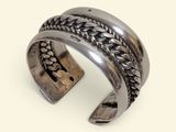 a close up of a silver bracelet with a chain on it