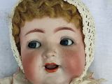 a close up of a doll with a hat on