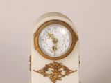 a white and gold clock sitting on top of a table