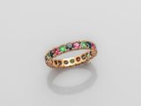 une bague en or ornée de pierres multicolores sur fond blanc