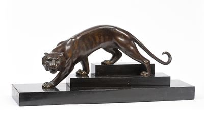 statue en bronze représentant un tigre, posée sur un socle noir, sur fond blanc