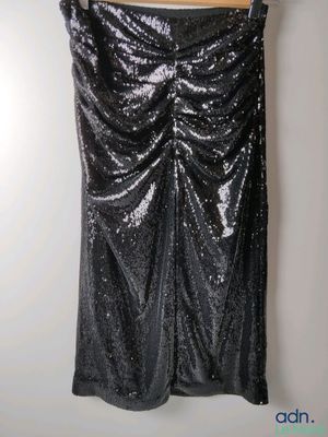 a black skirt with silver sequins hanging on a hanger