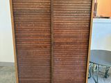 une armoire en bois avec une porte coulissante au milieu