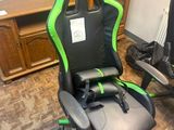a green and black racing chair in the corner of a room