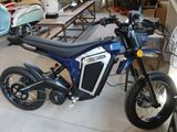 une moto bleue et noire garée dans un garage
