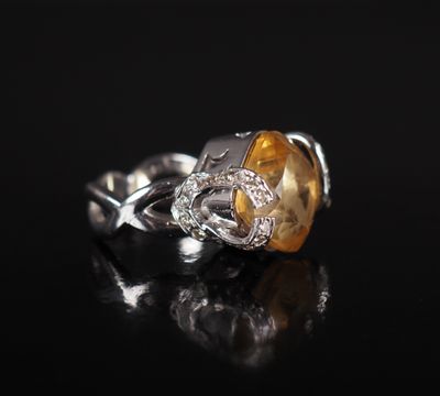 a close up of a yellow and white diamond ring on a black surface