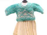 un pull et une jupe en maille présentés sur un mannequin, devant un fond blanc