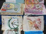 Plusieurs œuvres d'art sont posées sur une table devant une boîte bleue