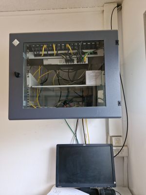 un ordinateur portable posé sur un bureau devant une armoire