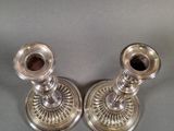 pair of silver candlesticks on a grey background