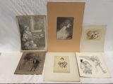 Plusieurs photographies anciennes représentant des femmes et des enfants sont exposées sur une table