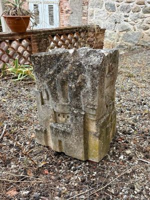 a stone block sitting in the middle of a garden