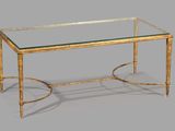une table basse en verre avec un piètement en métal doré