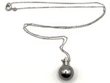 collier avec une perle noire sur une chaîne en argent, sur fond blanc