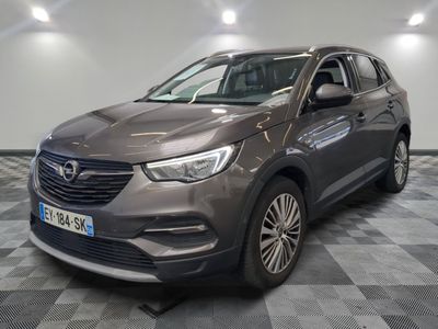 une voiture grise garée sur le sol en damier d'un garage
