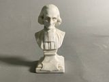 une petite statue représentant un homme assis sur une table