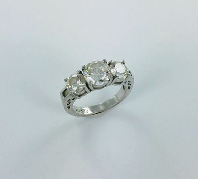 a three stone diamond ring on a white background