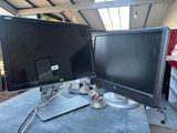 two computer monitors sitting on top of a table next to each other