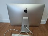 a white apple computer sitting on a wooden floor next to a keyboard and mouse