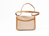beige canvas and leather handbag on white background with leather strap
