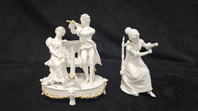 deux figurines blanches représentant des femmes jouant de la musique, posées sur une table